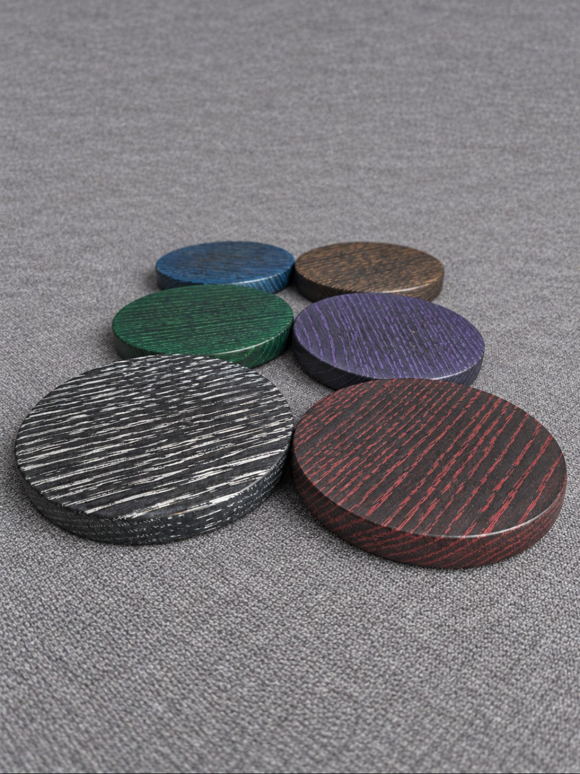 Ebonised oak coasters with white, red, green, purple, blue and bronze highlighted grain