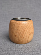 Single oak tealight holder showing its curved grain, rounded profile and stainless steel insert