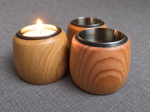 Cedar, Douglas fir and oak tealight trio arranged together with a candle lit in one holder