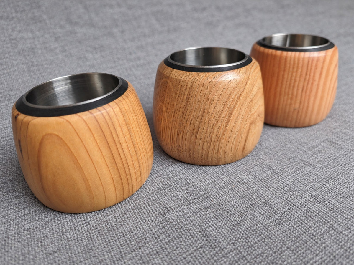 Three handcrafted tealight holders in western red cedar, Douglas fir and oak, showing their contrasting grain and stainless steel inserts